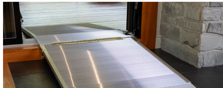 Rampe pliable portative en aluminium franchissant un seuil de porte